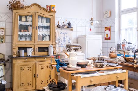 Eine historische Küche im Elektromuseum Rendsburg mit antiken Küchengeräten, einem Holzschrank und nostalgischen Dekorationen.