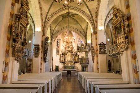 Prächtige Innenansicht der St. Marien Kirche in Rendsburg mit kunstvollem Altar, verzierten Wänden und hölzernen Kirchenbänken.