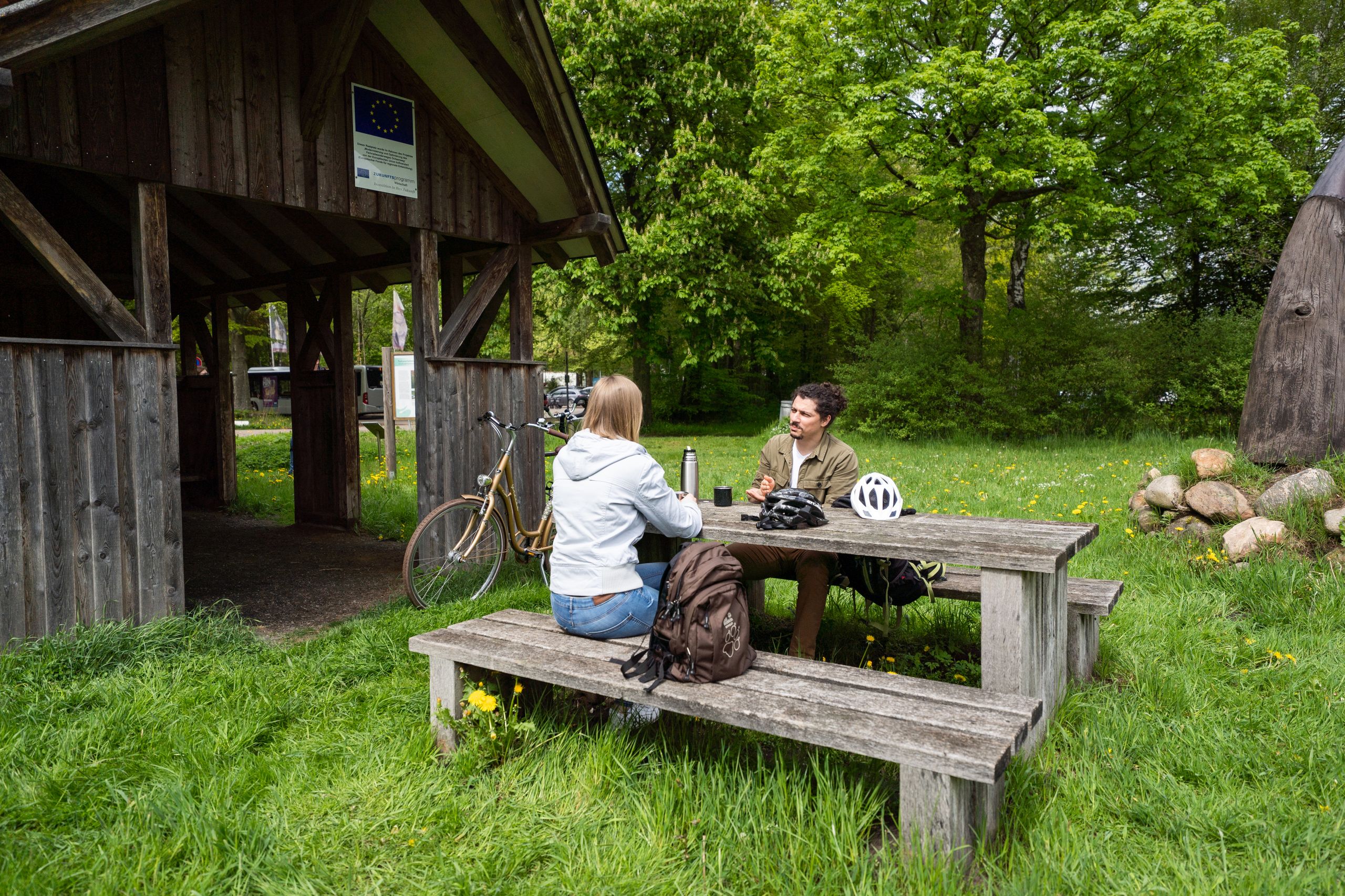 Radler machen am Rastplatz in der Nähe des Tierparks Neumünster eine Pause
