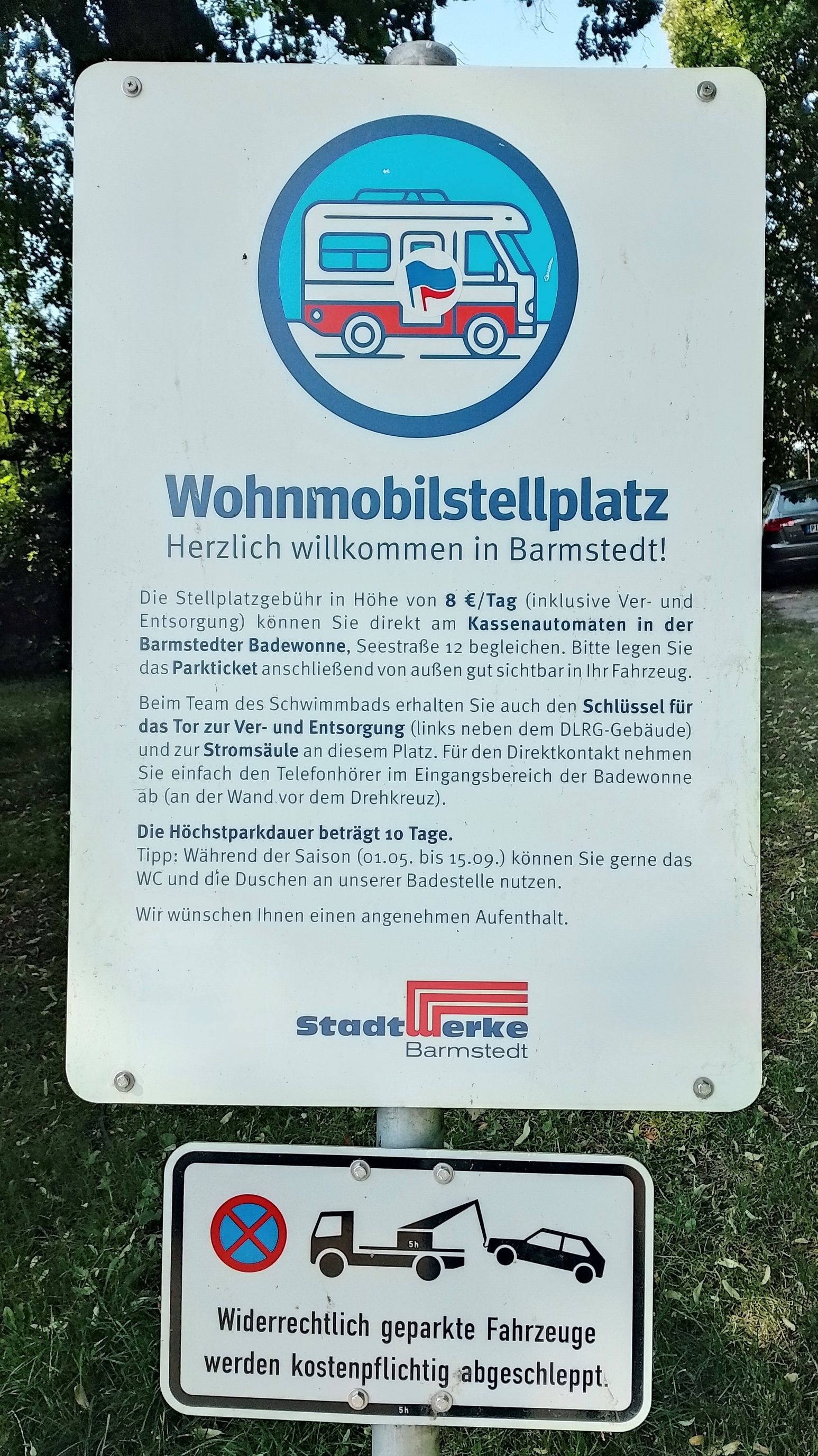 Schild für Wohnmobilstellplatz in Barmstedt mit Infos zu Gebühren, Parkdauer und Entsorgung. Unten Hinweis auf kostenpflichtiges Abschleppen.