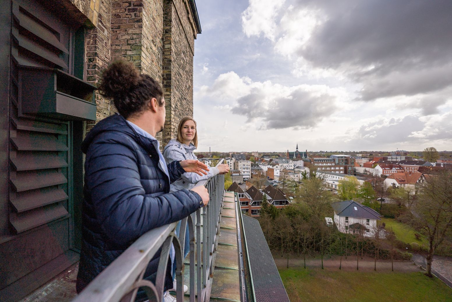 Zwei Personen auf der Aufsichtsplattform der Vicelinkirche mit Blick auf Neumünster