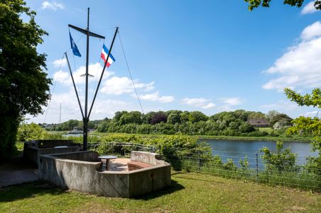 Aussichtspunkt in Schacht-Audorf mit Fahnenmast und Sitzbereich, umgeben von grüner Landschaft und Blick auf einen Fluss.