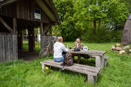 Radler machen am Rastplatz in der Nähe des Tierparks Neumünster eine Pause
