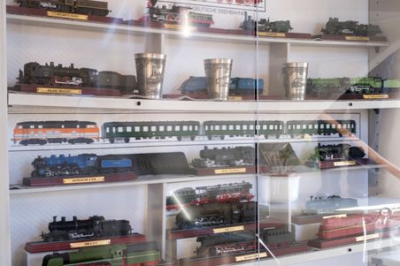 Eine Vitrine im Museumsstellwerk Rendsburg zeigt verschiedene Modelllokomotiven und Eisenbahnwagen. Die Modelle sind detailreich gestaltet.