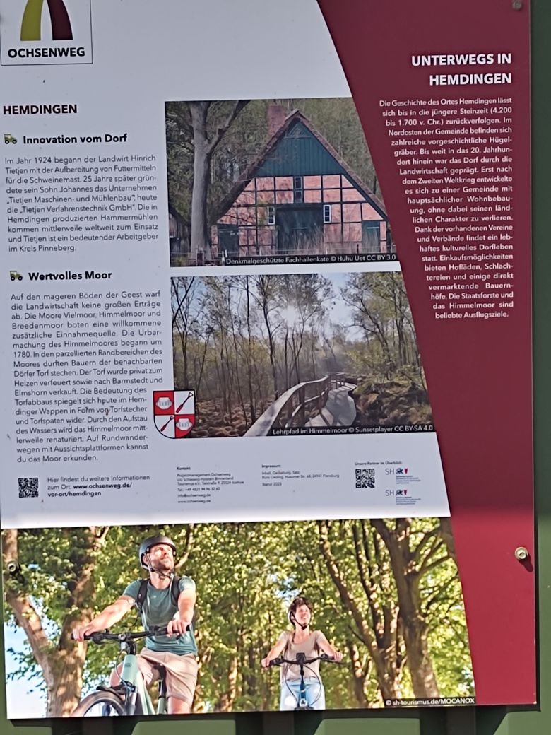Informationsschild über Hemdingen mit Details zur Geschichte, Sehenswürdigkeiten und Freizeitmöglichkeiten wie Radfahren und Moorwanderungen.