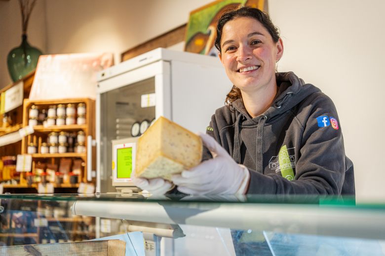 Die Betriebsleiterin steht im Hofladen hinter der Theke