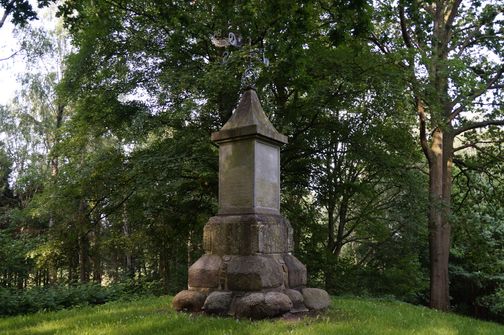 Der Tempel von Nordoe steht im Wald, umgeben von üppigem Grün und hohen Bäumen. Es hat eine quadratische Basis und eine dekorative Spitze.