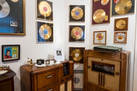 Goldene Schallplatten und ein altes Radio im Deutschen Schallplattenmuseum. Ein Bild von Elvis und antike Kameras ergänzen die Ausstellung.
