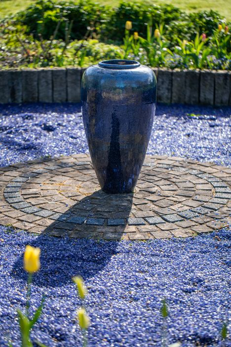 Blaues Glasgefäß im blauen Garten